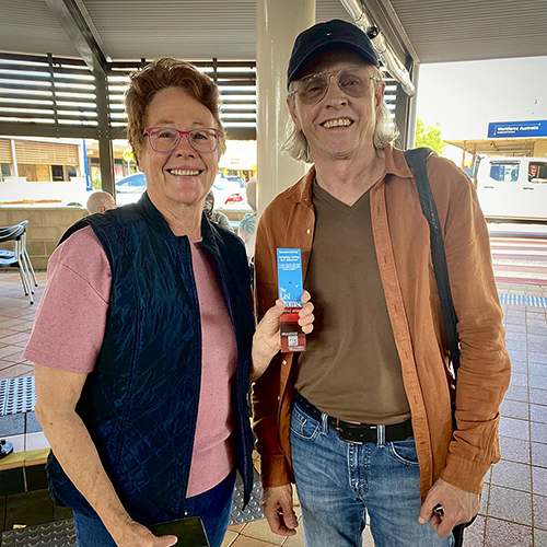 Robbie and Terrence in Dalby Robbie and Terrence pose for a photo, standing on the covered footpath outside the Coffee Club in Dalby. Robbie is holding up 'The Last Promise' bookmark. Smiles all round.